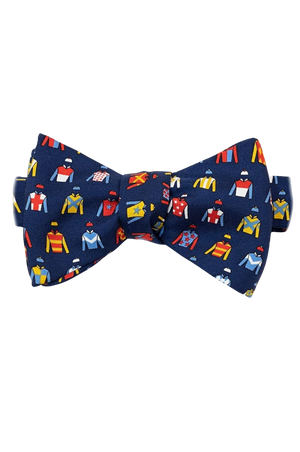A bow tie with a pattern of jockey silks in various colors on a navy background.