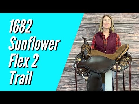 A brown western saddle with sunflower hand-tooling and turquoise patina copper berry hardware.