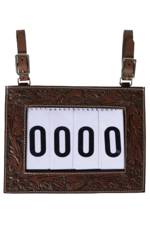 A tooled-leather number holder with adjustable straps and a white display for contestant numbers.