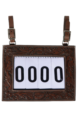 A tooled-leather number holder with adjustable straps and a white display for contestant numbers.