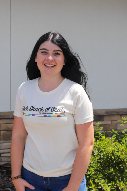 Person wearing a white t-shirt with text and graphics, standing outdoors.