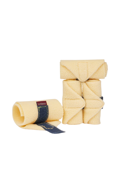 Two beige horse leg wraps with denim accents on a white background
