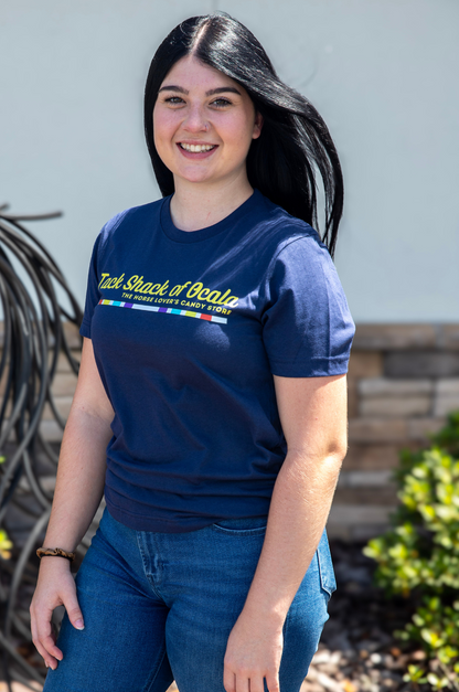 Woman wearing a blue t-shirt with text and graphics, standing outdoors.