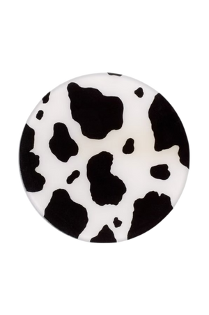 Round object with black and white cow print pattern on a white background