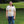 Person wearing a t-shirt with a graphic design standing in a grassy area.