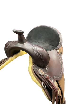 Close-up of a brown leather saddle with decorative elements on a white background
