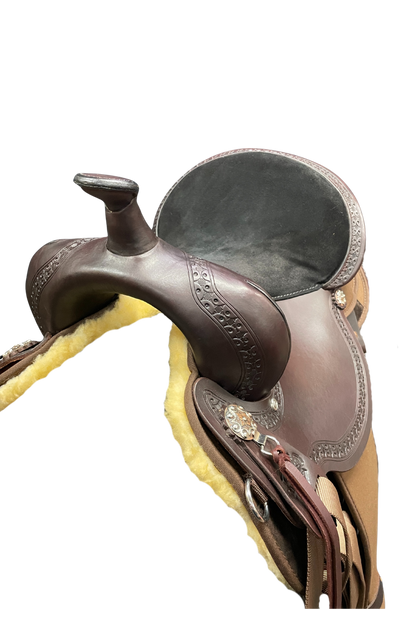 Close-up of a brown leather saddle with decorative elements on a white background