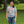 Person wearing a gray t-shirt with a humorous warning label in an outdoor setting