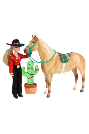 Barbie doll in cowboy outfit with horse and cactus toy on white background