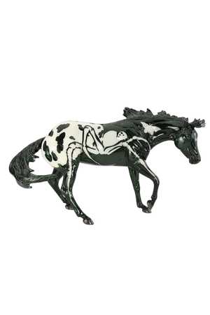 Model horse with black and white pattern on a white background