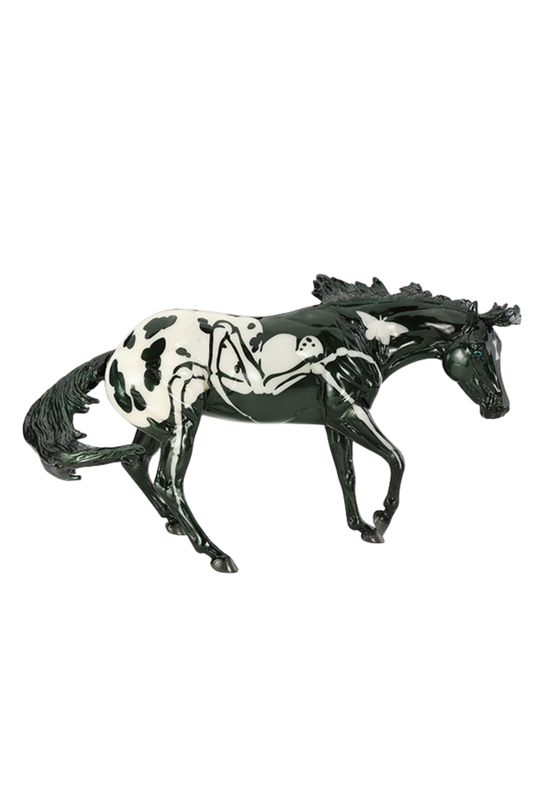 Model horse with black and white pattern on a white background